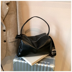 Detailansicht der schwarzen Leder-Shopper-Tasche mit Silberreißverschluss auf Koffer