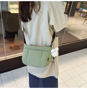 Vue latérale du sac bandoulière matelassé vert avocat avec un charm chien en peluche