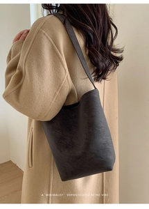 Minimalist retro tote bag in dark leather shown on a model during daily commute
