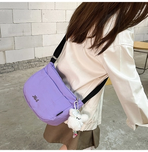 Détail du sac seau en nylon violet avec breloque chien en peluche et large bandoulière