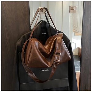 Nahaufnahme der braunen Vintage-Ledertasche mit breitem Gurt und Silberschnalle
