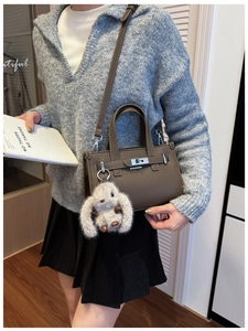 Brown litchi leather tote bag with silver lock and plush rabbit charm detail