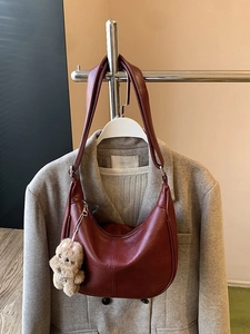 Burgundy faux leather crescent hobo bag with a cute puppy plush charm for women