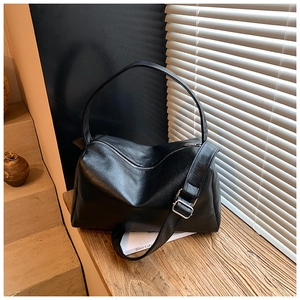 Nahaufnahme der schwarzen Ledertasche mit Silberschnalle auf einer sonnigen Fensterbank