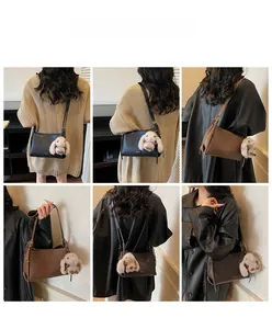 Detail showing high-quality pebbled leather shoulder bag with cute rabbit plush keychain