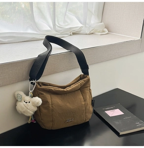 Détail du sac hobo matelassé marron café avec large bandoulière et pendentif en peluche