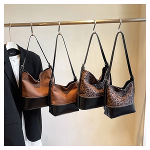 Detail of leopard print and brown suede tote bags with leather base and shoulder straps