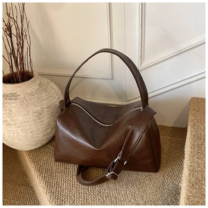 Detailansicht der dunkelbraunen PU-Ledertasche mit Silberbeschlägen auf rustikalem Grund
