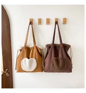 Detail of plush apple patch and drawstring closure on large canvas tote bags