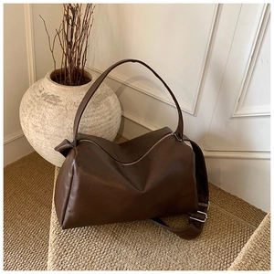 Detail der dunkelbraunen Leder-Shopper-Tasche mit matter Textur und Silber-Reißverschluss