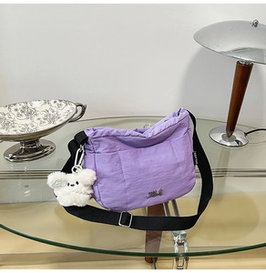 Vue détaillée du sac seau en nylon violet avec logo Karl et accessoire pendentif ours