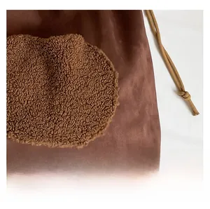 Dettaglio della borsa tote in pelle scamosciata marrone con inserti in pile e coulisse