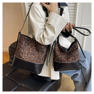 Detail of leopard print bucket bag set shown on a model in a modern interior setting