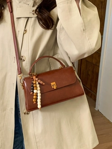 Sac à bandoulière marron vintage avec fermoir doré et pendentif décoratif en perles
