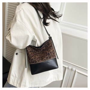 Detail showing high-quality leopard print suede and black leather stitching on a bucket bag