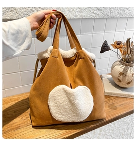Detail of plush tote bag featuring a brown suede finish and white sherpa heart patch