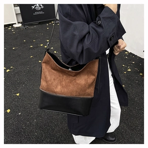 Street style shot of a woman wearing a vintage brown and black patchwork hobo bucket bag