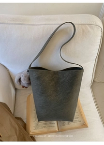 Deep olive bucket bag with textured leather and a cute grey plush bunny charm detail