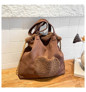 Close-up of vintage brown suede tote with teddy fur trim and a large heart-shaped patch