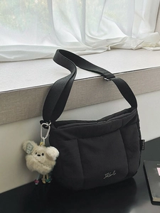 Sac seau matelassé noir avec bandoulière réglable et charm chien en peluche pour l'automne