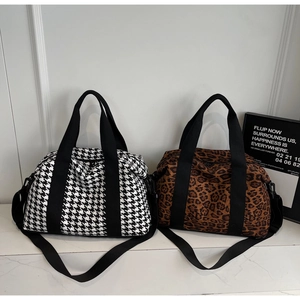 Detail view of large travel bags in classic houndstooth and leopard print patterns