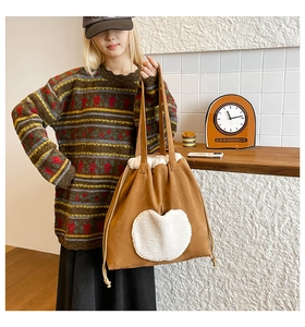 Detailed side view of brown canvas tote bag with a plush white heart patch and drawstring