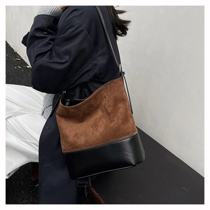 Detail of the large color-block bucket bag showing brown suede and black leather textures
