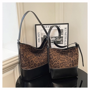 Detail view of leopard print bucket bag set with black leather base and metal zippers
