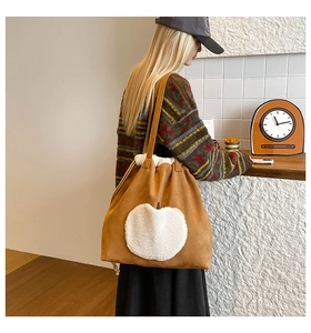 Detail of brown suede tote bag featuring a white faux fur apple patch and plush lining