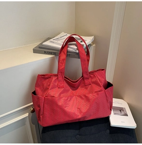 Detail of red plaid canvas tote bag showing multiple pockets and spacious interior