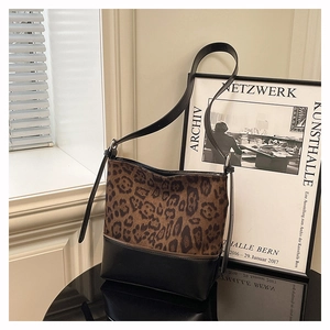 Detail view of the leopard print patchwork and black leather shoulder bag design