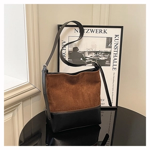 Close-up of the vintage brown suede and black leather patchwork bucket bag with zipper detail
