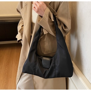 Detail of black nylon crescent bag with leather buckle and fashionable leather text