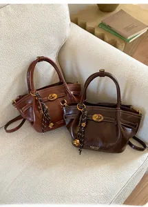 Close-up of vintage leather bucket bags with gold twist locks and decorative key charms
