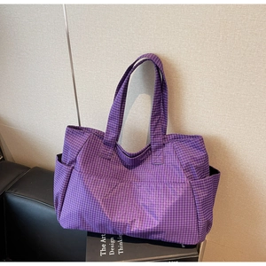Détail d'un sac cabas à carreaux violets avec poches latérales et anses solides