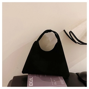 Detail of the matte black faux suede tote bag featuring a seamless integrated circular handle