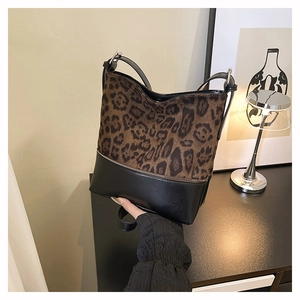 Detail of leopard print suede bucket bag with black leather base and metallic buckle