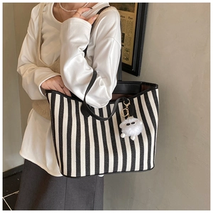 Close-up of black and white striped canvas tote with plush sheep charm detail