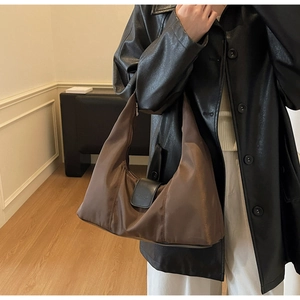 Detail of dark brown nylon hobo bag with black leather buckle closure for commuting