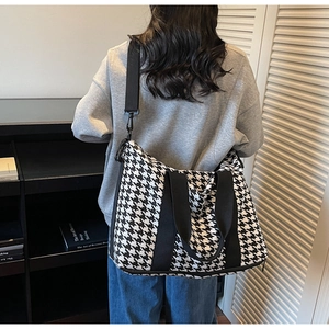 Classic houndstooth travel tote bag shown on model featuring black and white woven pattern