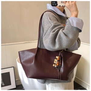 Detail of vintage chocolate brown tote bag with stylish wooden bead tassel decoration