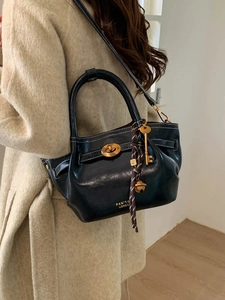 Elegant black leather bucket bag with white stitching and gold charms for women