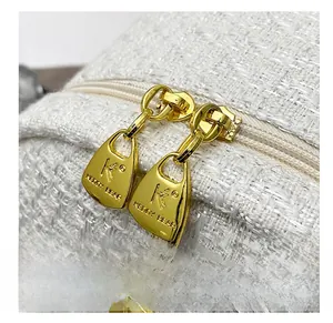 Detail show of golden dual zippers with logo on white tweed backpack fabric