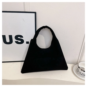 Detail of minimalist black frosted suede tote bag with a unique triangular silhouette