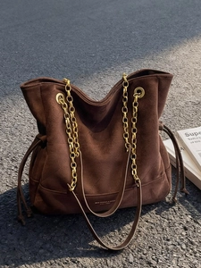 Sac fourre-tout minimaliste en daim marron foncé avec chaîne dorée et texture matelassée