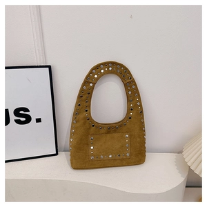 Makroaufnahme von Silbernieten und gelbem Wildleder-Struktur an einer Vintage-Tasche