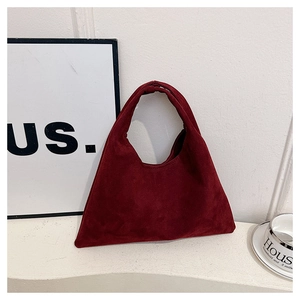 Detailed view of the burgundy matte faux suede finish and minimalist tote bag texture
