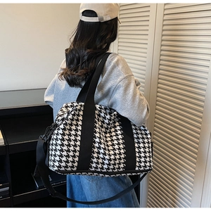 Detail of black and white houndstooth travel tote with detachable shoulder strap