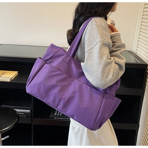 Detail of purple plaid tote bag showing high-density canvas texture and side pocket