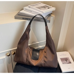 Close-up of dark brown nylon hobo bag with leather strap and fashion buckle detail